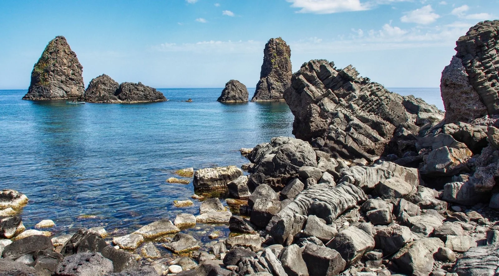 Columnar basalt cliffs and sea stacks along the Cyclops Coast near Aci Trezza