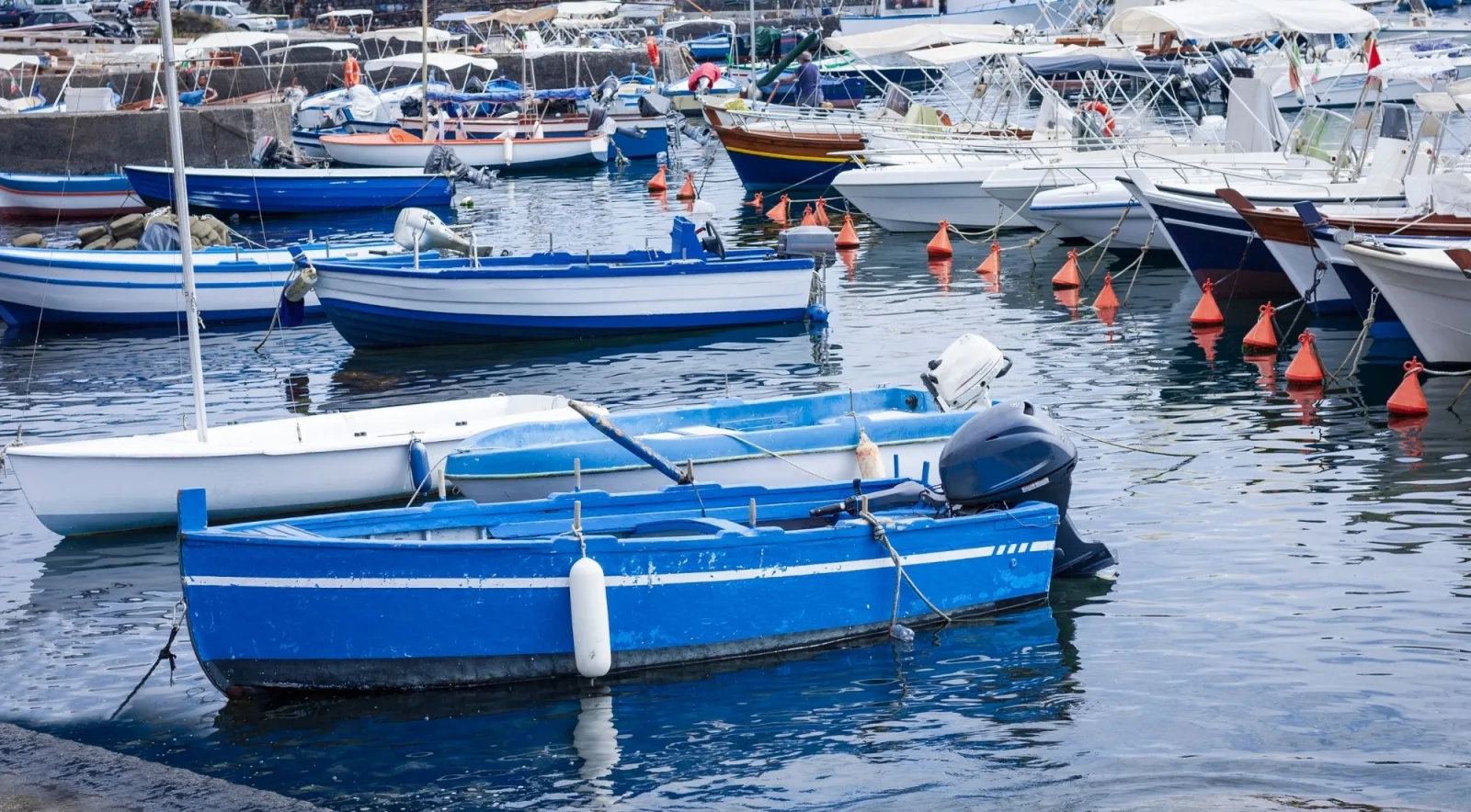 Traditional wooden fishing boats moored in Aci Trezza's small harbour