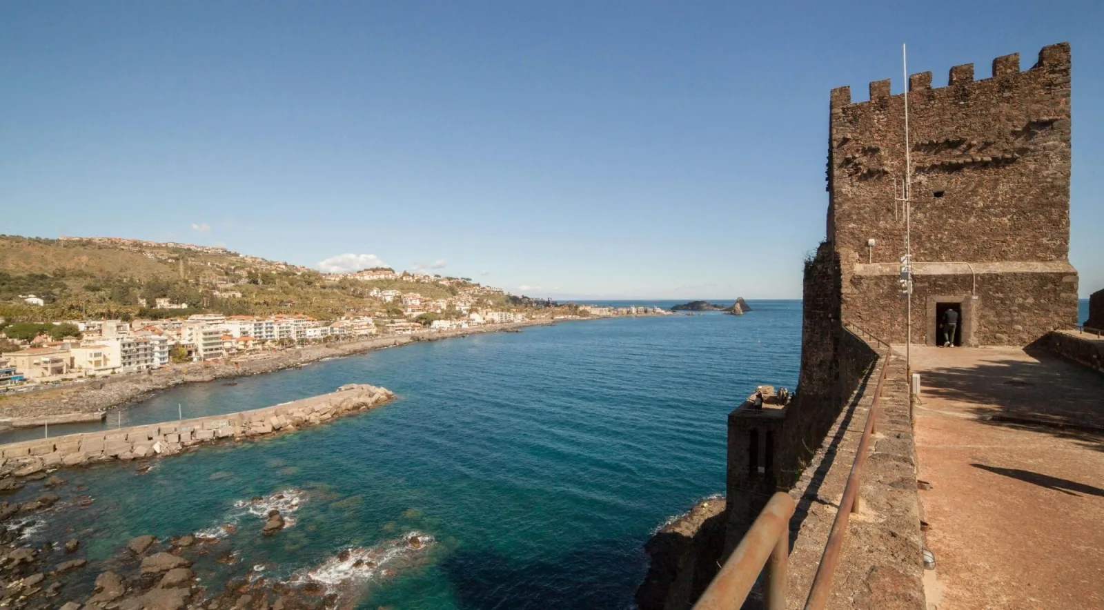 The medieval Norman Castle of Aci Castello perched on a lava cliff above the sea