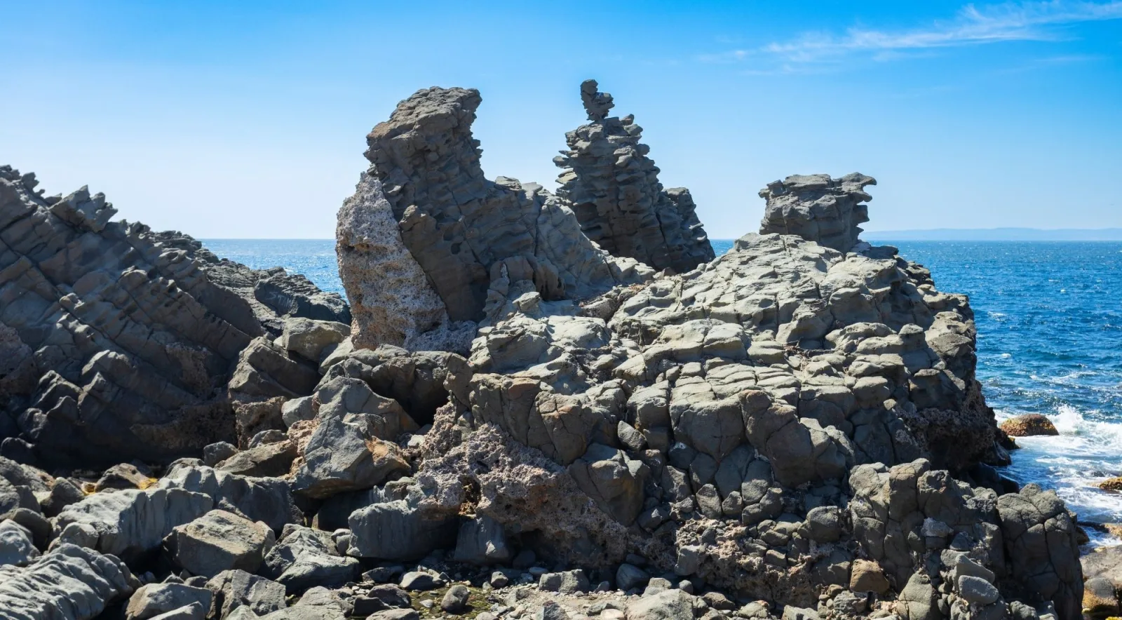 Jagged volcanic sea stacks along the Cyclops Coast shaped by centuries of wind and waves