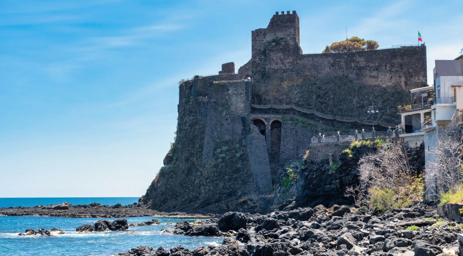 Aci Castello's clifftop castle above the rocky Ionian shoreline near Catania