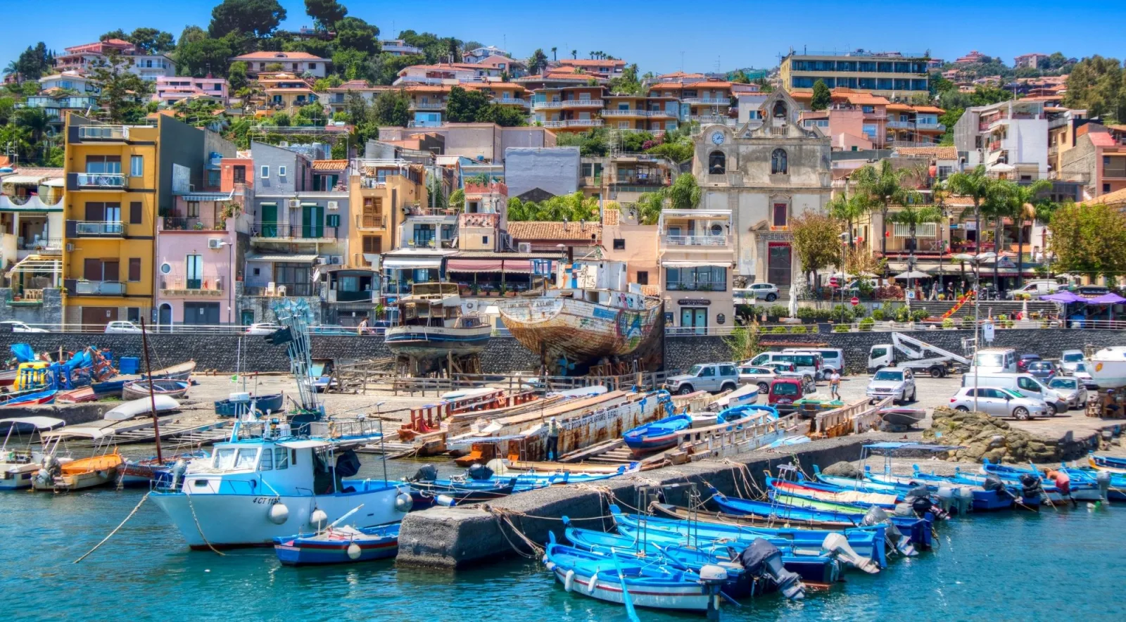 Colourful houses and fishing boats along the waterfront of Aci Trezza