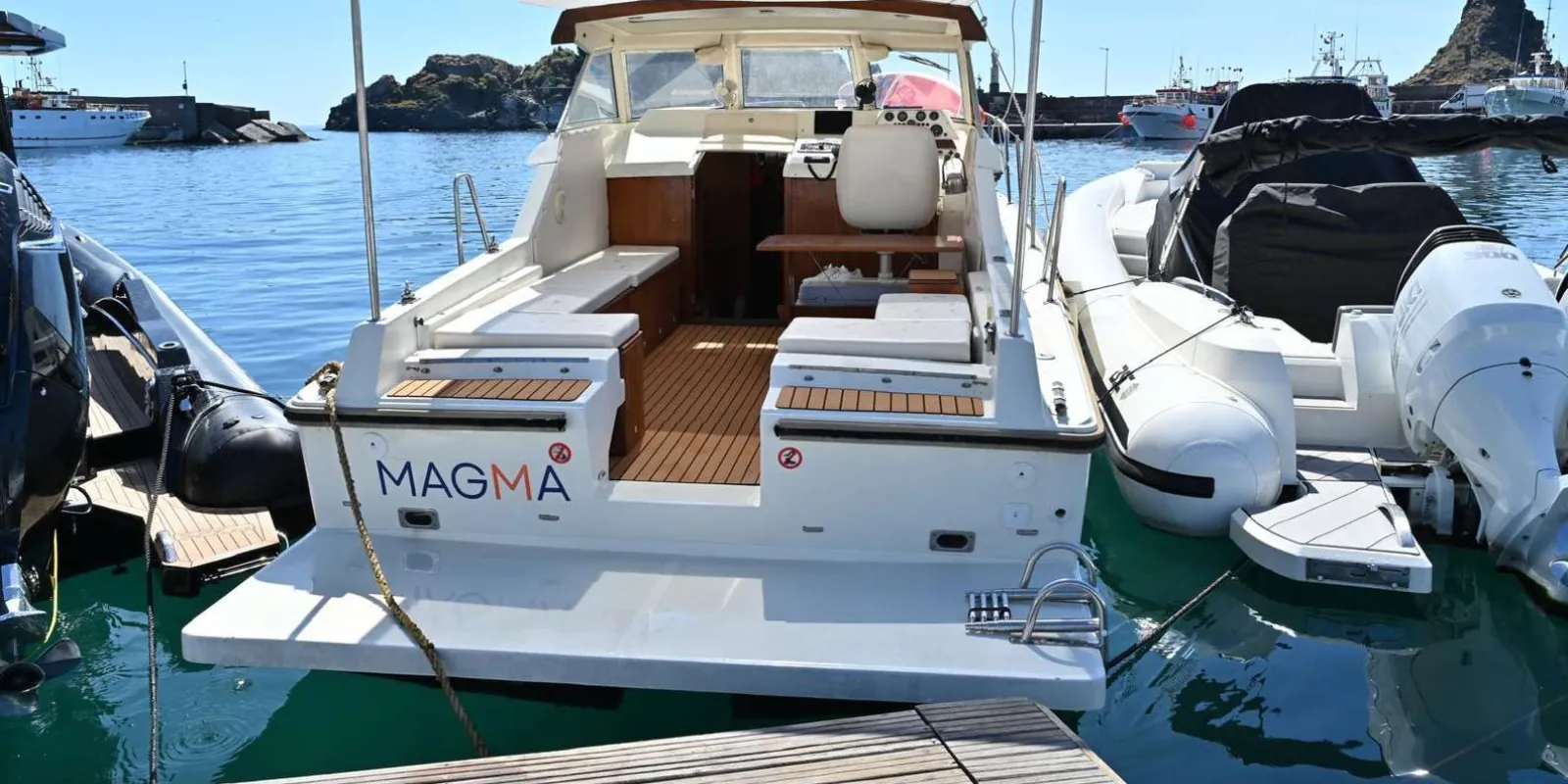 Guests enjoying drinks and fruit on board during the Faraglioni boat excursion