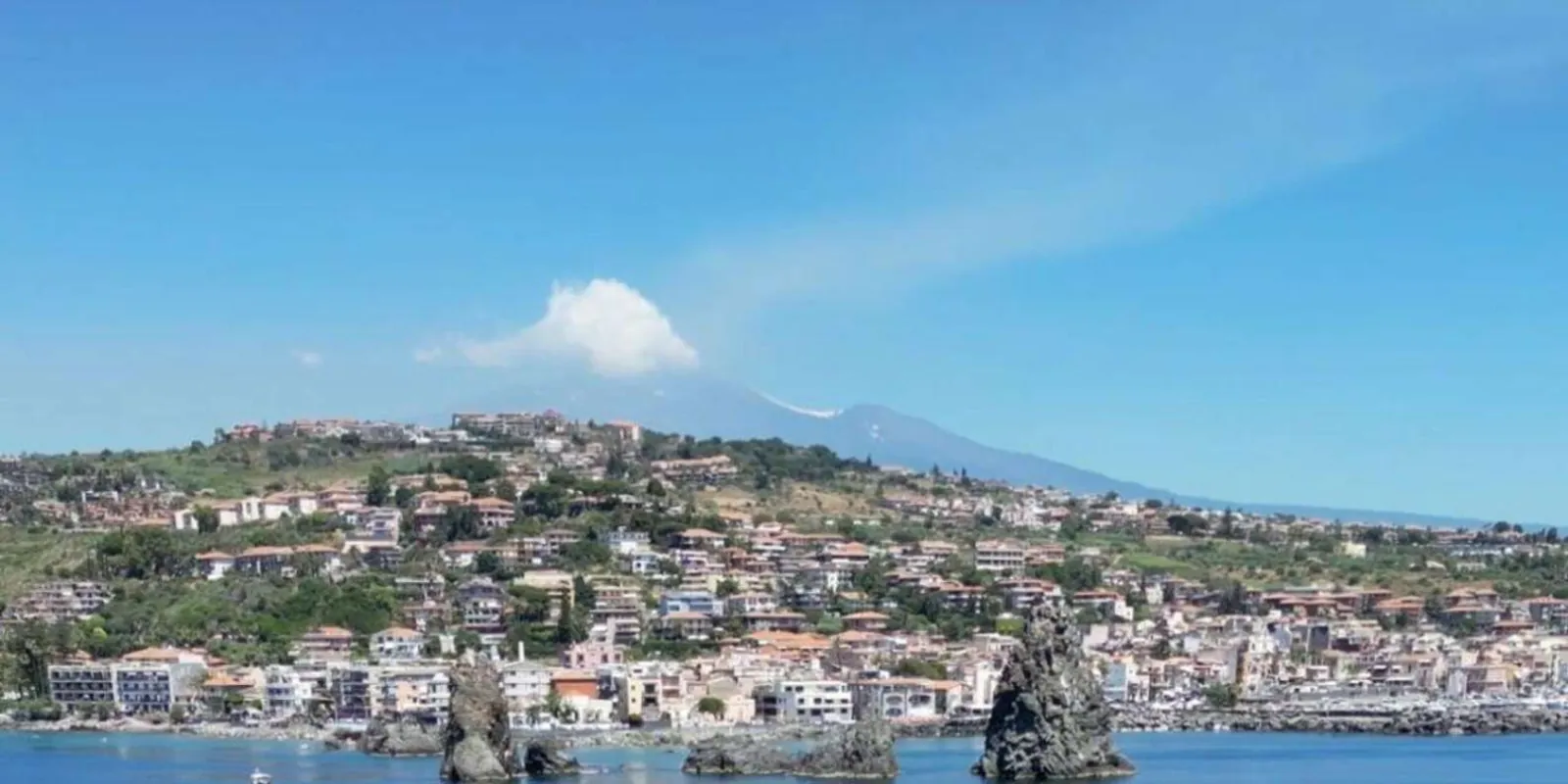 The Faraglioni sea stacks rising from the Ionian Sea near Acitrezza